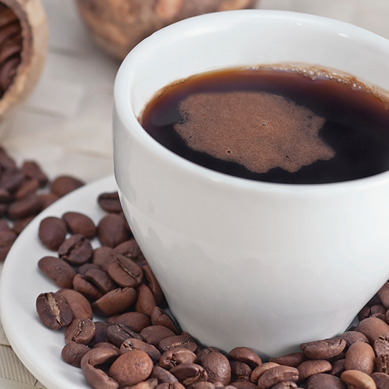 Coffee cup with roasted coffee beans, close-up